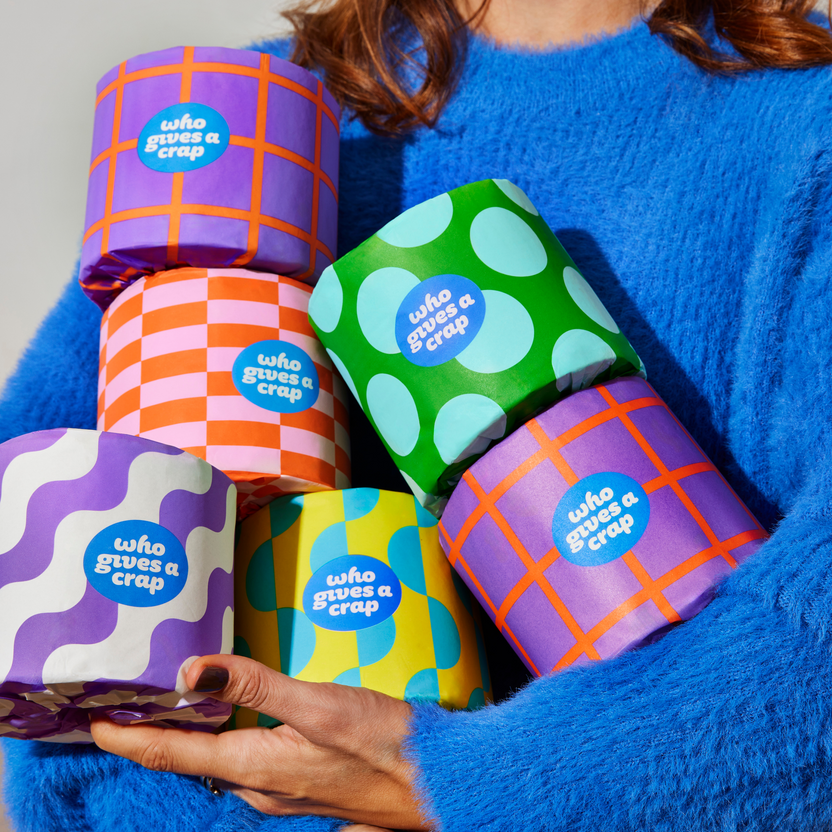 Woman holds handful of colourful Who Gives a Crap recycled toilet paper rolls Woman holds handful of colourful Who Gives a Crap recycled toilet paper rolls