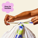 Two hands ties close Who Gives a Crap large recycled bin bag with the easy tie handles.