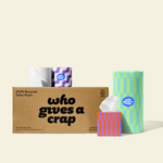 Two rolls and a box of Who Gives a Crap compostable rubbish bags with green packaging