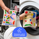 Dirty and soiled Who Gives A Crap Dream Cloths being loaded into a dishwasher and a washing machine to demonstrate that the cloths are reusable and safe for machines.