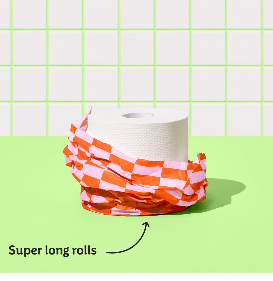 Single roll of Who Gives a Crap recycled toilet paper against green and while bathroom wall, with text reading ‘Super long rolls’