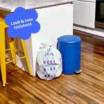 Who Gives a Crap medium recycled bin bag sits full next to kitchen bin. Caption in corner reads ‘Leak & tear resistant’.