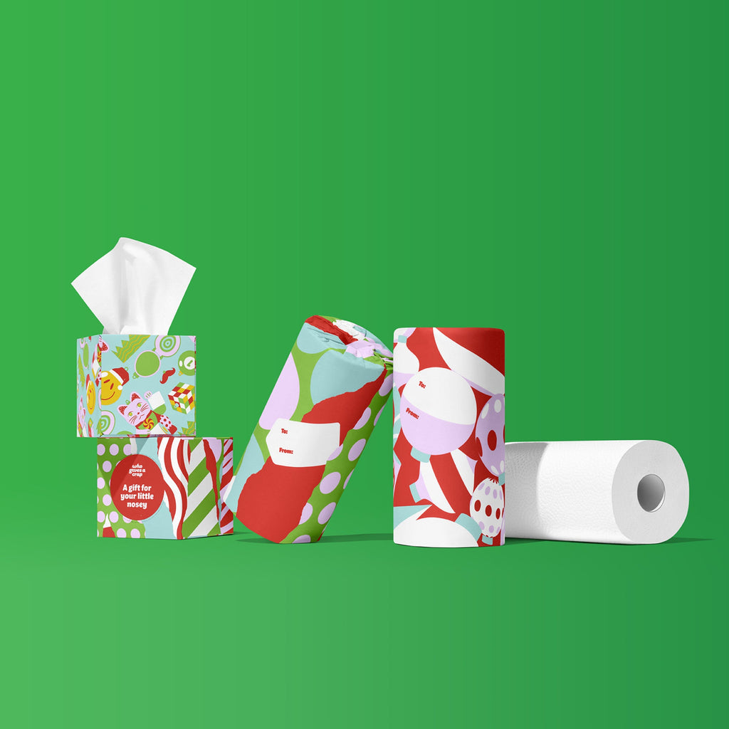 Perfect Pair tissue boxes and wrapped paper towel rolls standing together with an unwrapped white paper towel roll on a green background.