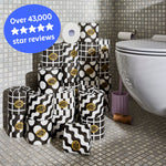 Several rolls of wrapped and unwrapped Premium Toilet Paper sits on the bathroom floor next to a toilet. Caption reads ‘over 43,000 five star reviews’.